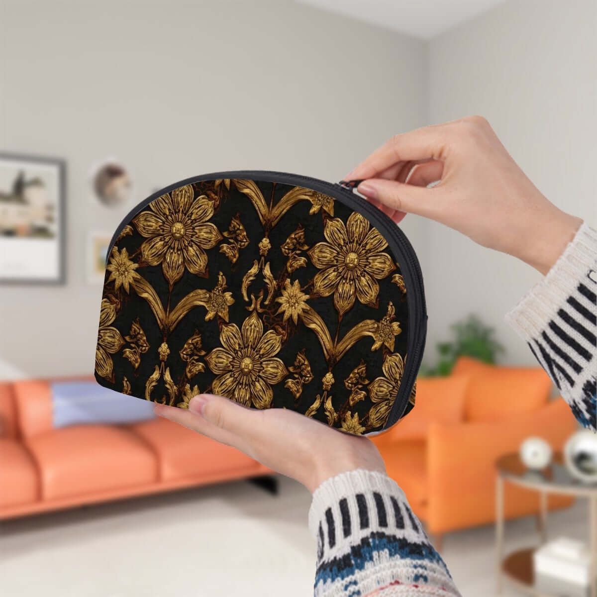Person holding a large floral Storage Bags Set of 2 with black and gold design in a living room, featuring zipper closure and spacious interior.