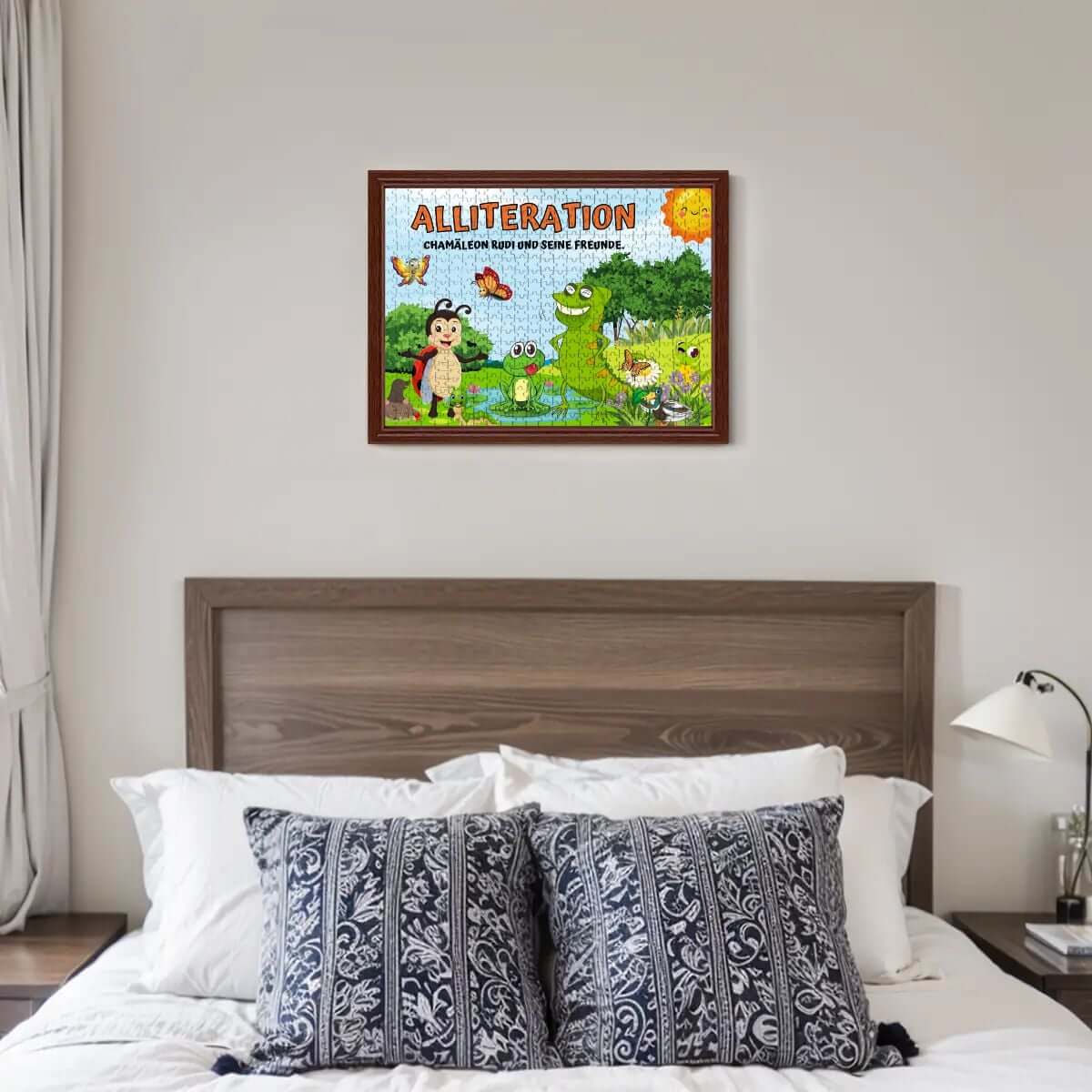 Framed alliteration challenge poster above bed in modern bedroom with patterned pillows.