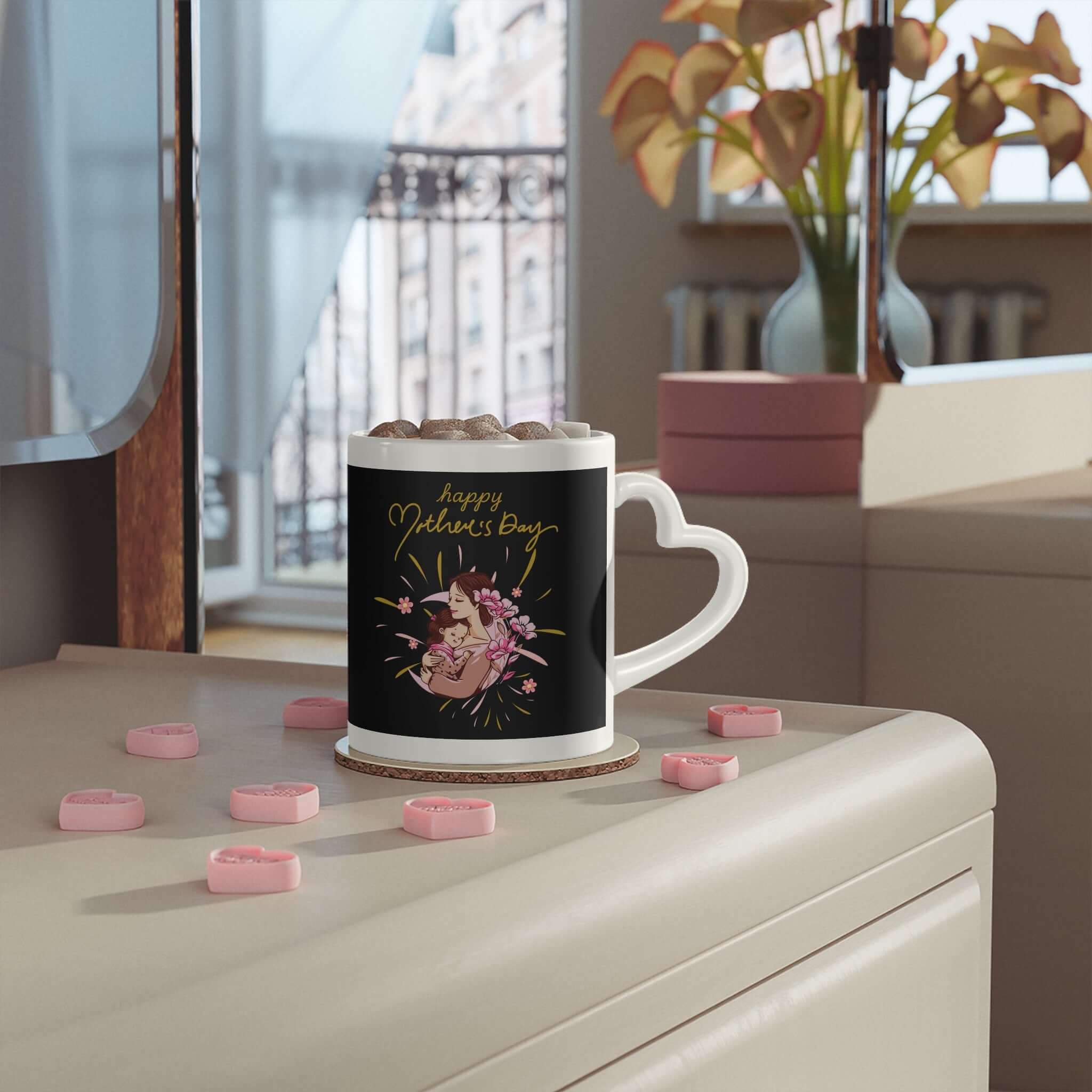 Herzförmige Henkeltasse mit ein Liebesmotiv auf schwarzem Hintergrund, rosa Herz-Dekor und Blumen in einer gemütlichen Wohnungsszene.
