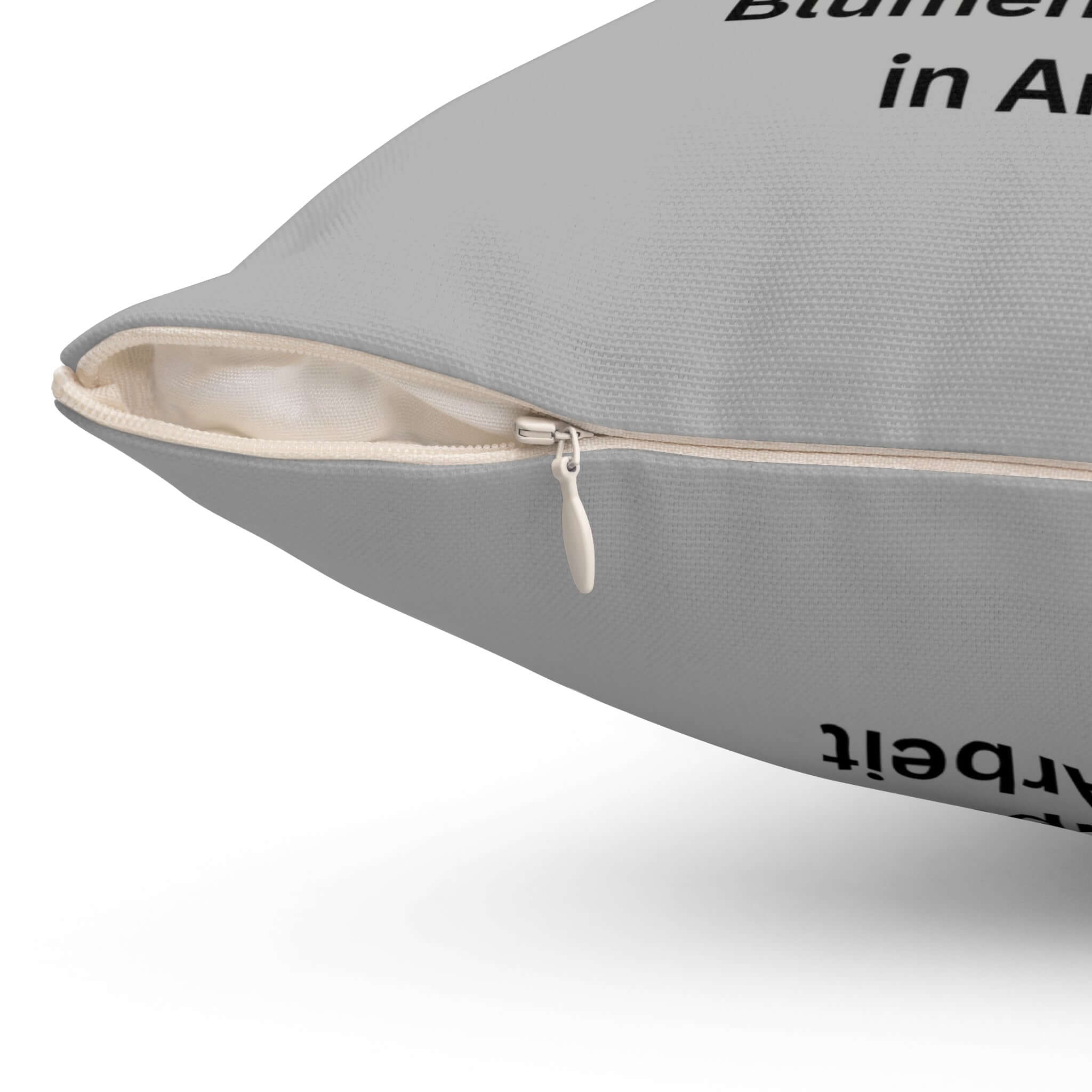 Nahaufnahme des skurrilen Raupenkissens für Pflanzenliebhaber mit Reißverschluss auf hellgrauem Hintergrund.