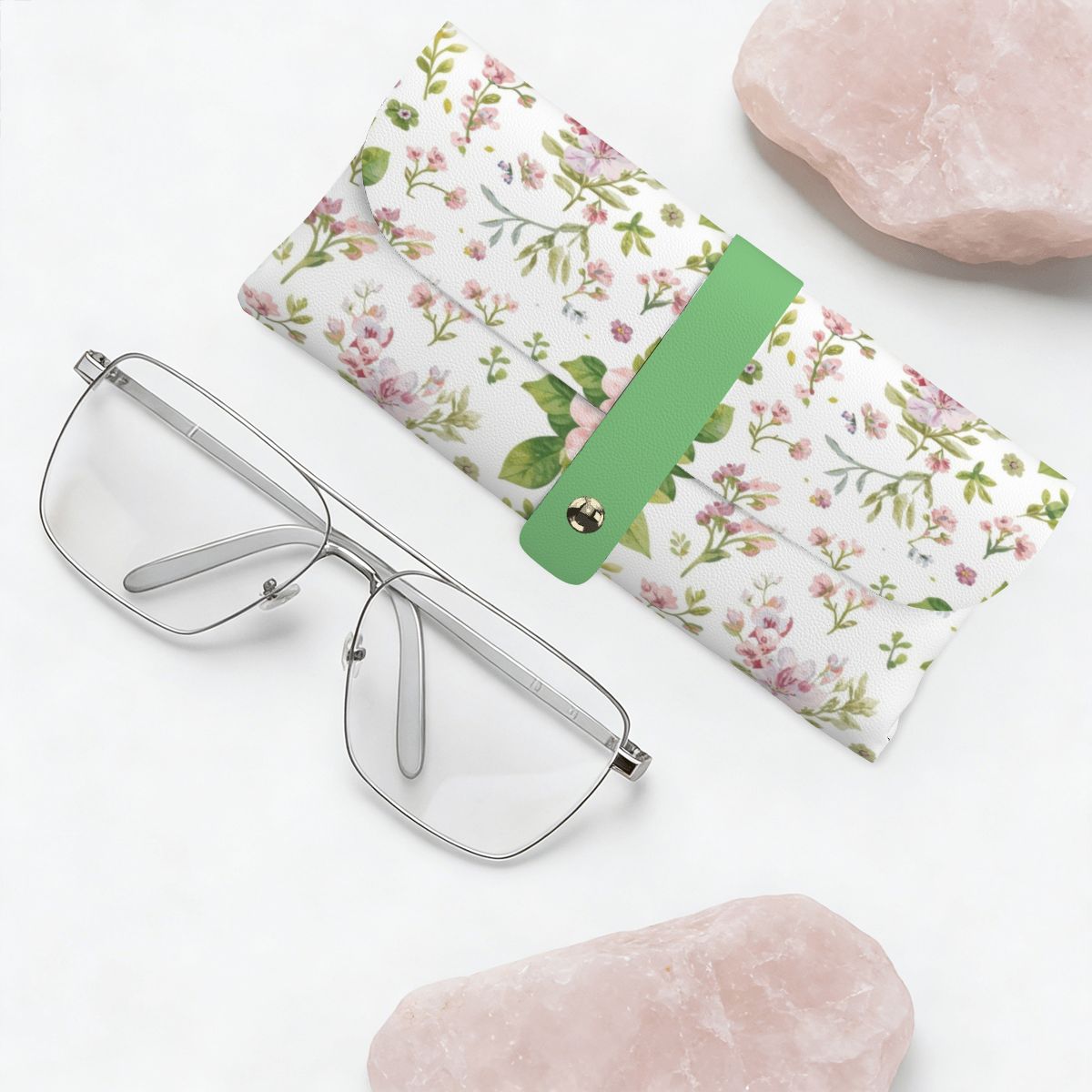 Brillenetui aus PU-Leder mit floralem Design, Brille und Rosenquarz präsentieren Eleganz und Schutz.
