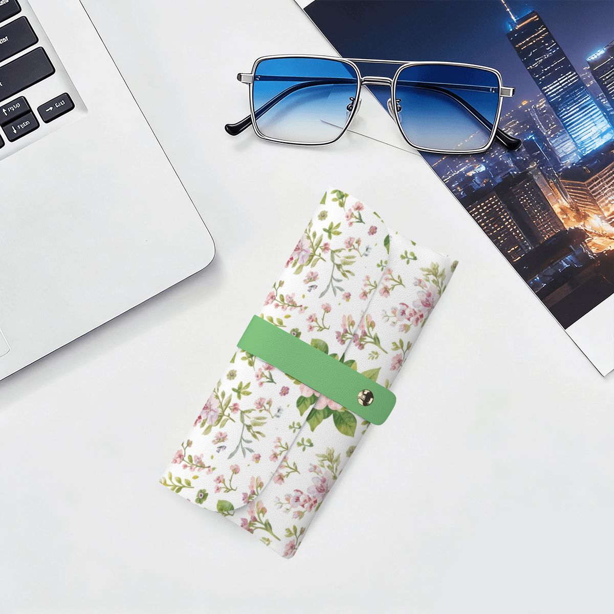 Brillenetui aus PU-Leder mit floralem Design neben Laptop und Sonnenbrille, ideal für kratzfreien Schutz von Brillen.