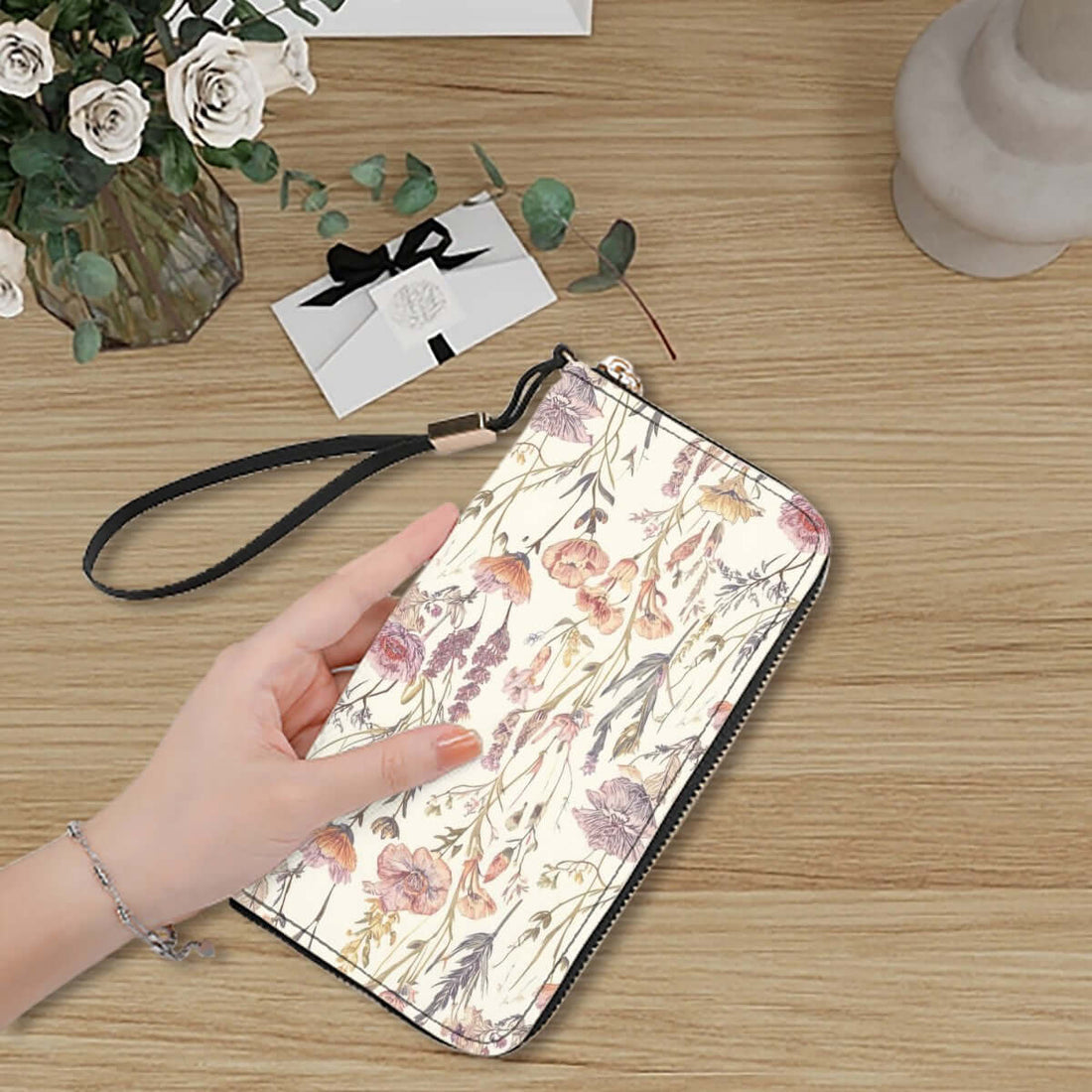 Blumendruck Clutch-Geldbörse für Damen aus PU, 4,1"x7,9", auf einem Holztisch mit Hand und Blumenstrauß im Hintergrund.