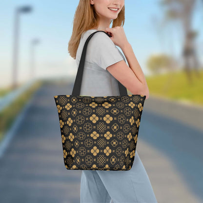 Frau trägt eine stilvolle Polyester Schultertasche zum Einkaufen in Schwarz mit goldenen Mustern, Größe 11"x7"x13".