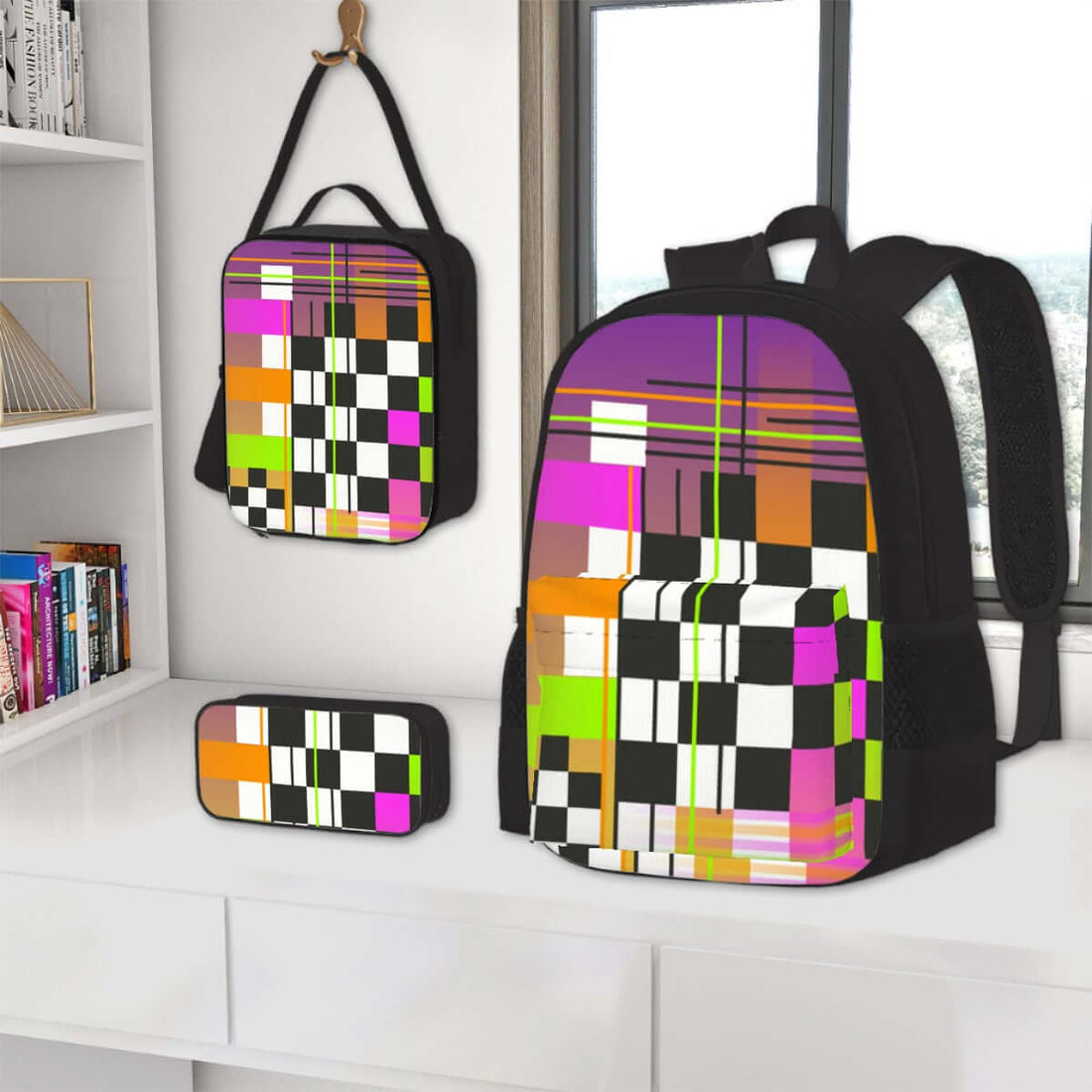 3er-Set Taschen (Oxford-Rucksack, Lunchtasche &amp; Federmäppchen) mit buntem Muster auf einem Tisch vor einem Fenster