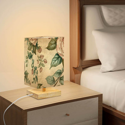 Quadratische Tischlampe aus Leinen mit Blumenmuster und Holzsockel auf Nachttisch, schafft gemütliche Beleuchtung im Schlafzimmer.