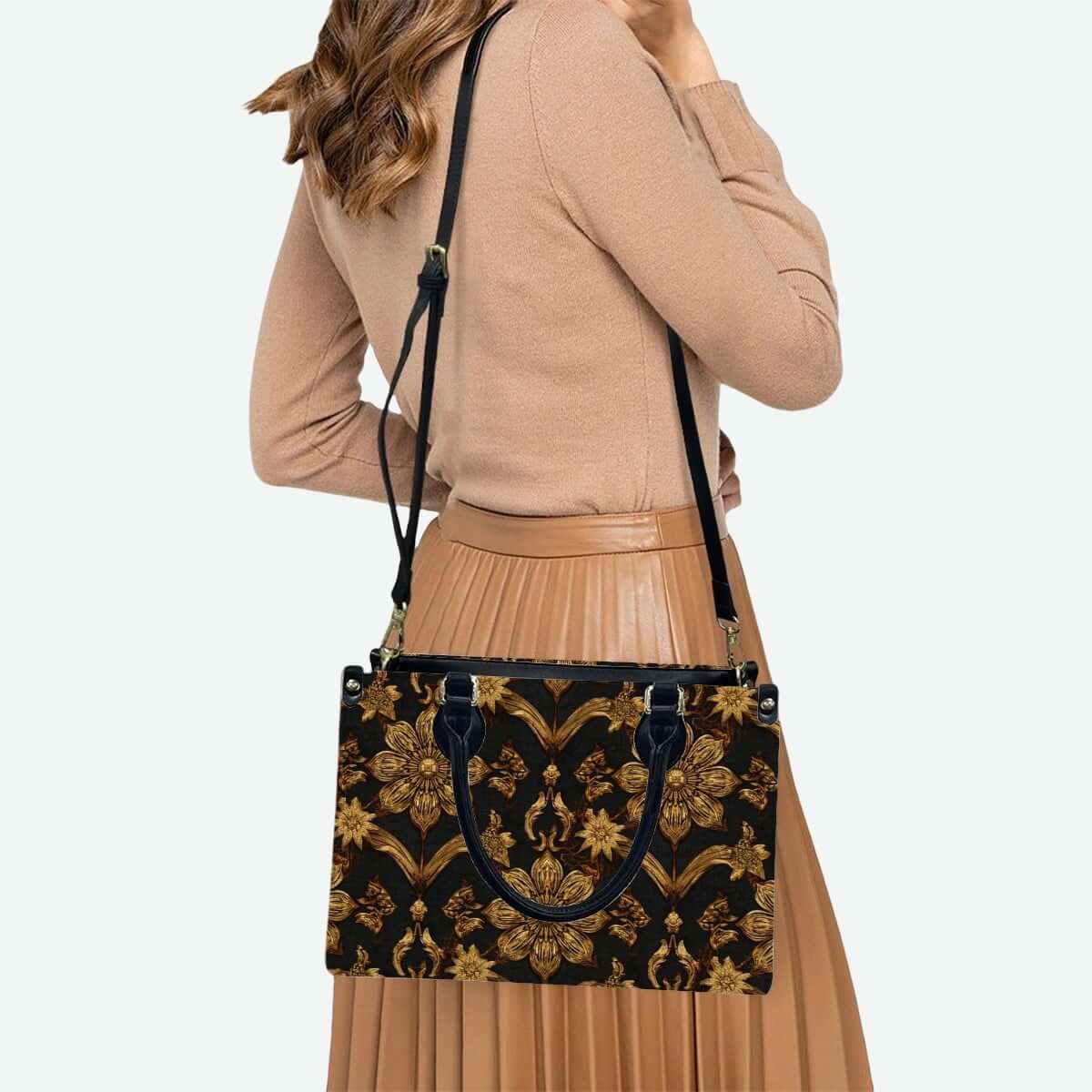 Woman carrying a PU Tote Bag for Women with golden pattern design, black handles and zipper, over her shoulder. Details für PU-Tragetasche für Damen ansehen.