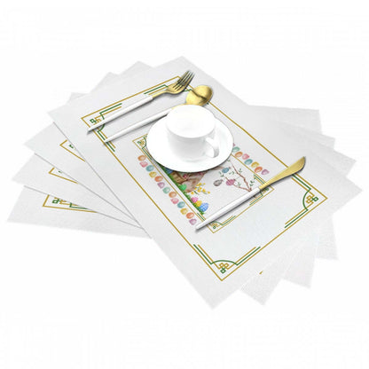 Tischset aus gewebtem PVC mit goldenen Utensilien und weißer Tasse, hitzebeständig bis 80 °C, kratz- und fleckenresistent.