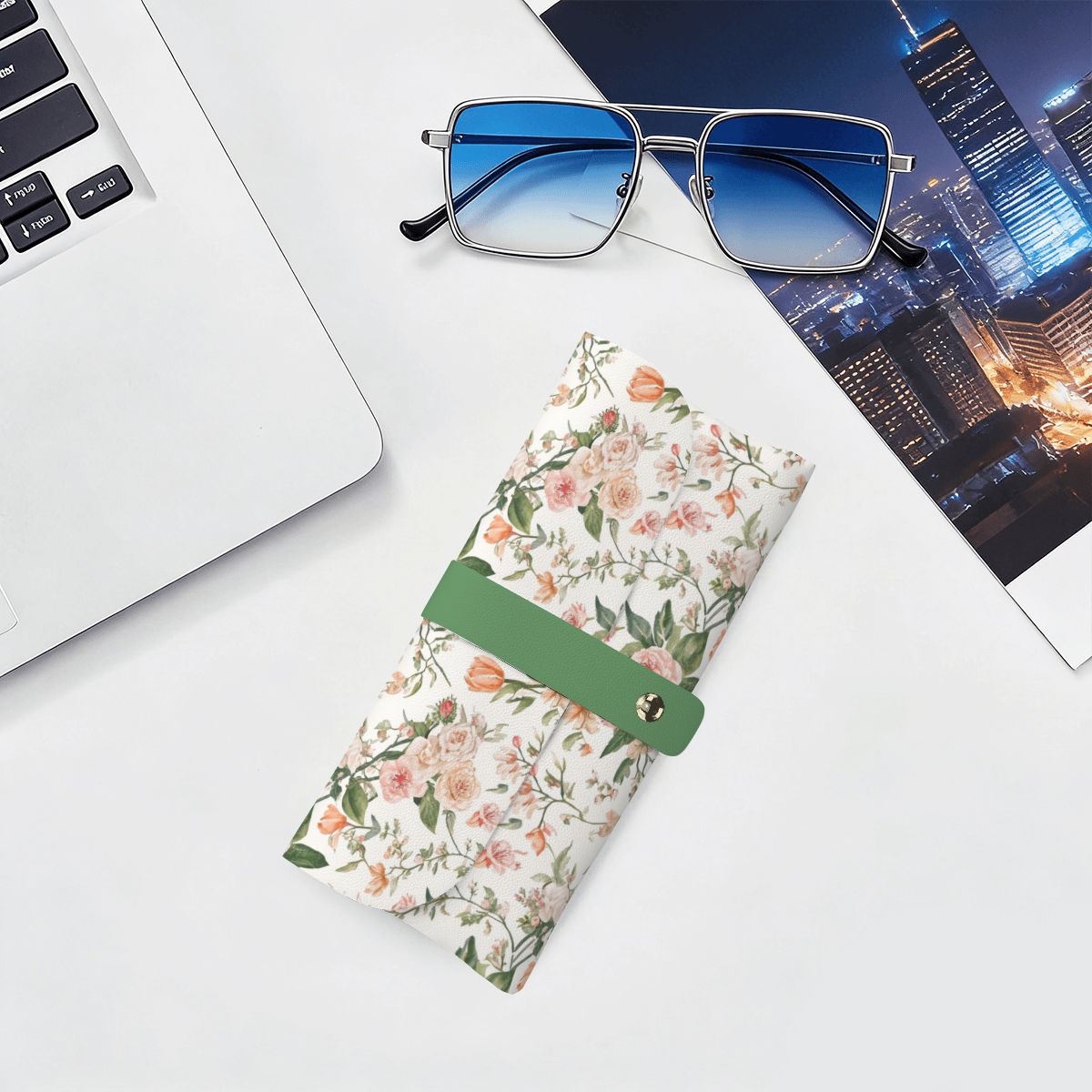 Brillenetui aus PU-Leder mit Blumenmuster, auf einem Schreibtisch neben einer Brille und Laptop platziert.