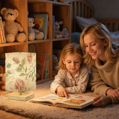 Quadratische Tischlampe mit floralem Design aus Leinen und Gummiholz in gemütlicher Leseszene, verbreitet warmes und diffuses Licht.