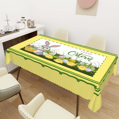 Rechteckige Tischdecke mit Wellenrand Ostermotiv auf einem Esstisch, gelb mit Osterhasen und Küken, wasserabweisend und faltbar.