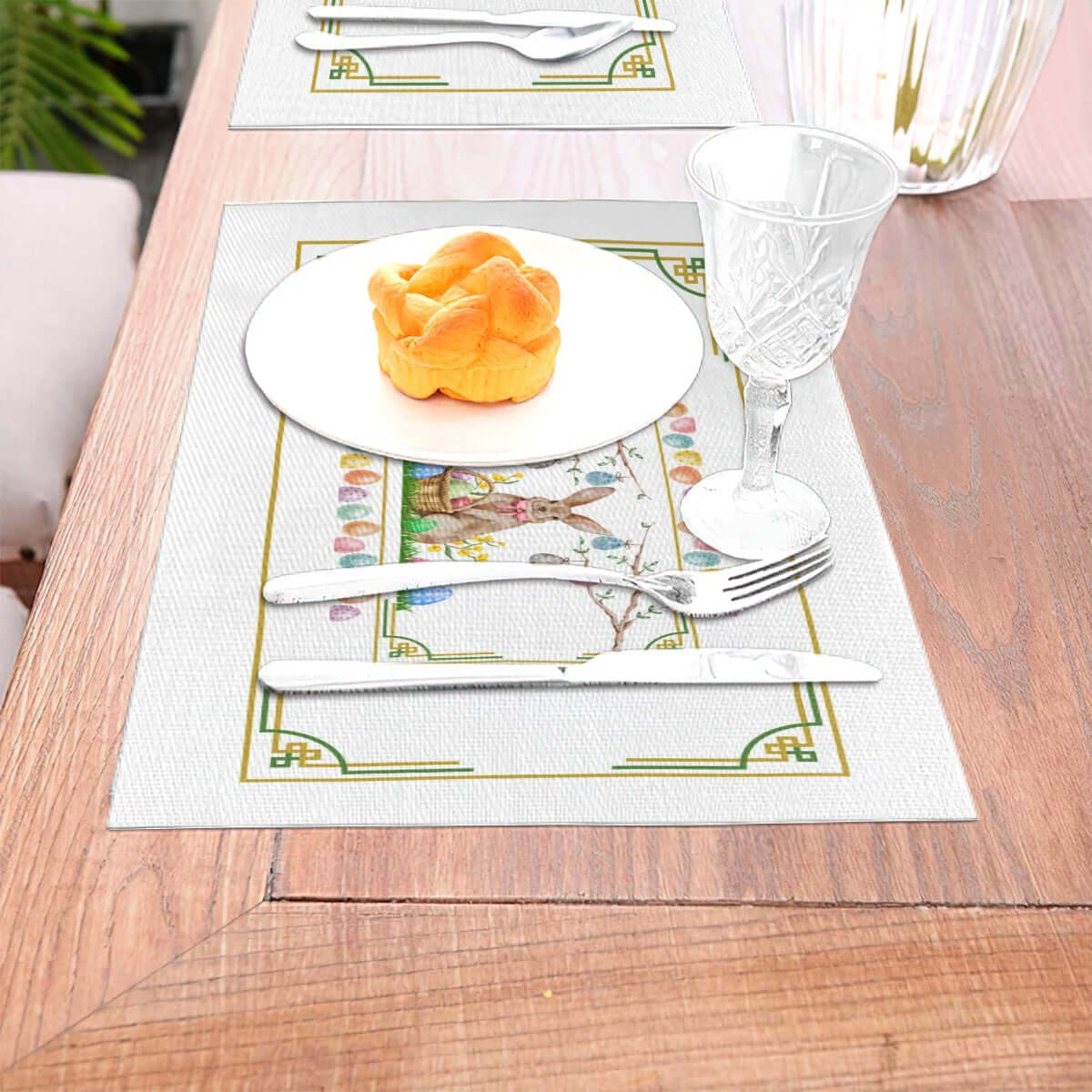 Tischset aus gewebtem PVC auf Holztisch mit Teller, Besteck und Weinglas. Details für Tischset aus gewebtem PVC ansehen.