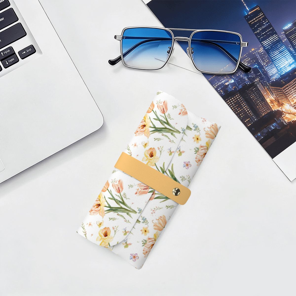 Brillenetui aus PU-Leder mit floralem Design auf einem Schreibtisch neben Laptop und Sonnenbrille