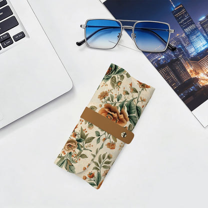 Brillenetui aus PU-Leder mit Blumenmuster neben Sonnenbrille und Laptop, ideal für die Aufbewahrung von Brillen, stilvoll und funktional.