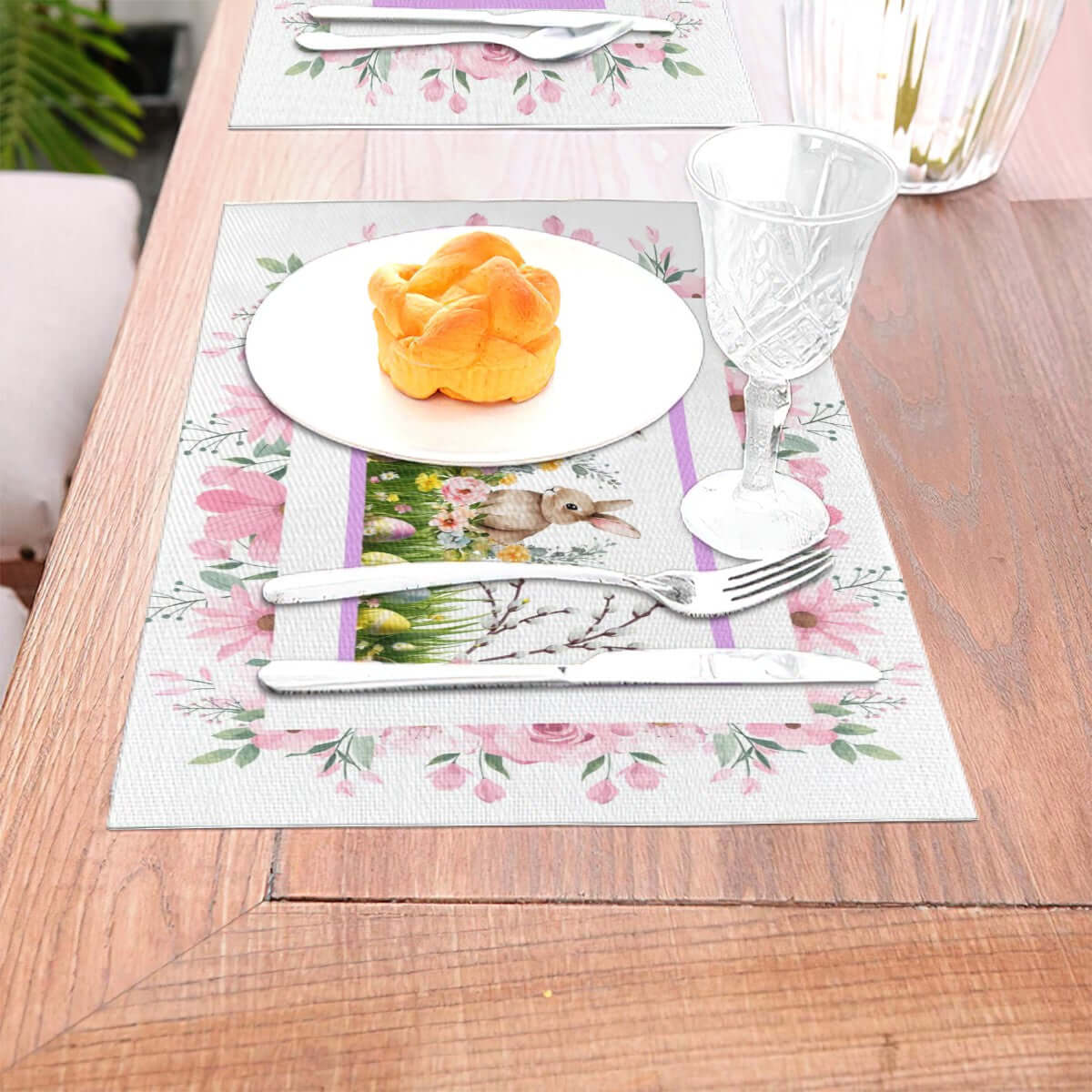 Tischset aus gewebtem PVC mit floralem Design, 18"x12", kratzfest und hitzebeständig bis 80 °C, auf einem gedeckten Esstisch.